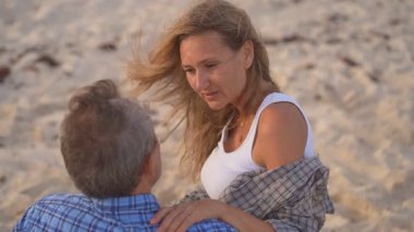 Romantik orta yaşlı çift kumsalda huzurlu bir akşamın tadını çıkarıyor. Olgun ilişkiler ve yavaş yaşam tarzı için aşk, bağlantı ve birliktelik kavramı