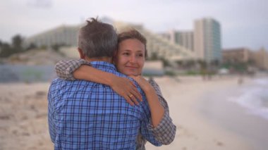 Romantik orta yaşlı çift kumsalda huzurlu bir akşamın tadını çıkarıyor. Olgun ilişkiler ve yavaş yaşam tarzı için aşk, bağlantı ve birliktelik kavramı