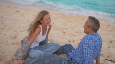 Romantik orta yaşlı çift kumsalda huzurlu bir akşamın tadını çıkarıyor. Olgun ilişkiler ve yavaş yaşam tarzı için aşk, bağlantı ve birliktelik kavramı