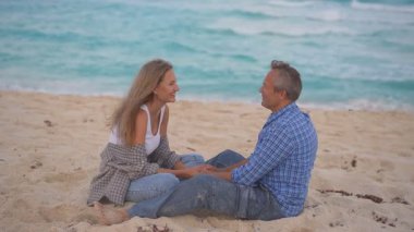 Romantik orta yaşlı çift kumsalda huzurlu bir akşamın tadını çıkarıyor. Olgun ilişkiler ve yavaş yaşam tarzı için aşk, bağlantı ve birliktelik kavramı