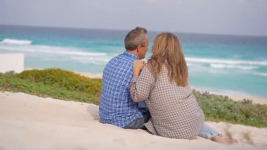Romantik orta yaşlı çift kumsalda huzurlu bir akşamın tadını çıkarıyor. Olgun ilişkiler ve yavaş yaşam tarzı için aşk, bağlantı ve birliktelik kavramı