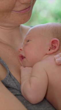 Genç bir anne sevgiyle kucağında küçük bebeğini kucağına alır. Yürek ısıtan bir bağ ve şefkat anını paylaşır. Aşkın güzel bir ifadesi, bağlanma ve anneliğin başlangıcı.