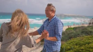 Romantik orta yaşlı çift kumsalda huzurlu bir akşamın tadını çıkarıyor. Olgun ilişkiler ve yavaş yaşam tarzı için aşk, bağlantı ve birliktelik kavramı