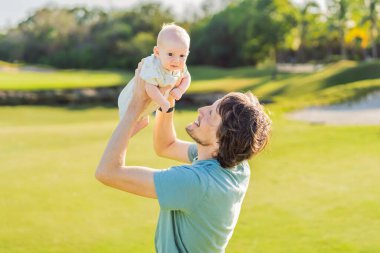 Baba ve yeni doğmuş bebek parkta bir çayırda. Doğada sevgi ve bağlanma anı. Ebeveynlik, babalık ve aile bağları kavramı.