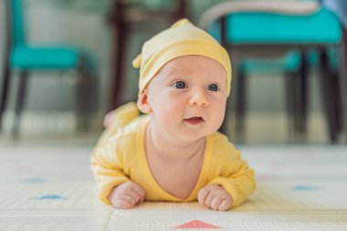 Bir aylık bir bebek karnının üstünde yatıyor ve tuhaf bir şekilde çevreyi gözlemliyor. Boyun dayanıklılığı, bilişsel gelişim ve erken keşif için bebek midesi zamanı. Ebeveynlik ve yeni doğan büyüme kavramı.