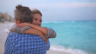 Romantik orta yaşlı çift kumsalda huzurlu bir akşamın tadını çıkarıyor. Olgun ilişkiler ve yavaş yaşam tarzı için aşk, bağlantı ve birliktelik kavramı