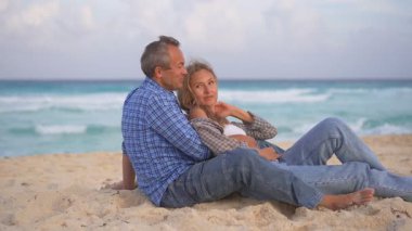 Romantik orta yaşlı çift kumsalda huzurlu bir akşamın tadını çıkarıyor. Olgun ilişkiler ve yavaş yaşam tarzı için aşk, bağlantı ve birliktelik kavramı