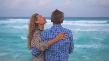 Romantik orta yaşlı çift kumsalda huzurlu bir akşamın tadını çıkarıyor. Olgun ilişkiler ve yavaş yaşam tarzı için aşk, bağlantı ve birliktelik kavramı