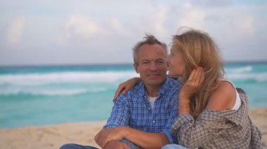 Romantik orta yaşlı çift kumsalda huzurlu bir akşamın tadını çıkarıyor. Olgun ilişkiler ve yavaş yaşam tarzı için aşk, bağlantı ve birliktelik kavramı