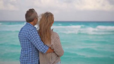 Romantik orta yaşlı çift kumsalda huzurlu bir akşamın tadını çıkarıyor. Olgun ilişkiler ve yavaş yaşam tarzı için aşk, bağlantı ve birliktelik kavramı