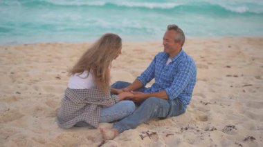 Romantik orta yaşlı çift kumsalda huzurlu bir akşamın tadını çıkarıyor. Olgun ilişkiler ve yavaş yaşam tarzı için aşk, bağlantı ve birliktelik kavramı
