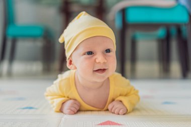 Bir aylık bir bebek karnının üstünde yatıyor ve tuhaf bir şekilde çevreyi gözlemliyor. Boyun dayanıklılığı, bilişsel gelişim ve erken keşif için bebek midesi zamanı. Ebeveynlik ve yeni doğan büyüme kavramı.