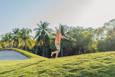 Pilot şapkası takan bir çocuk oyuncak bir uçakla çimlerde koşuyor, maceralar hayal ediyor. Çocukluk, hayal gücü ve özgürlük kavramı..