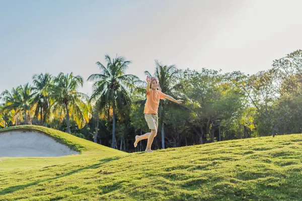 Pilot şapkası takan bir çocuk oyuncak bir uçakla çimlerde koşuyor, maceralar hayal ediyor. Çocukluk, hayal gücü ve özgürlük kavramı..