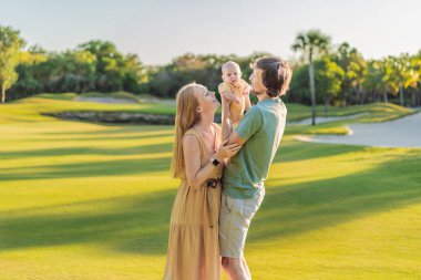 Yeni doğmuş bebekleriyle parktaki çayırda sevgi dolu ebeveynler. Mutlu aile doğanın tadını çıkarıyor, bağ kuruyor ve dışarıda huzurlu anlar yaşıyor. Ebeveynlik, sevgi ve aile bağları kavramı.