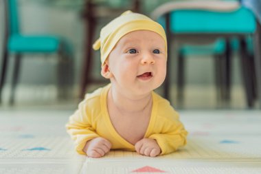 Bir aylık bir bebek karnının üstünde yatıyor ve tuhaf bir şekilde çevreyi gözlemliyor. Boyun dayanıklılığı, bilişsel gelişim ve erken keşif için bebek midesi zamanı. Ebeveynlik ve yeni doğan büyüme kavramı.