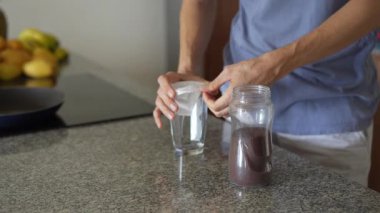 Genç bir adam sütlü filtre kahve hazırlar ve onu içmekten zevk alır. Rahatlatıcı ve tatmin edici bir an kahve yapma, kendine dikkat etme ve rahat bir ev ortamında rahatlama.