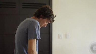 Genç bir adam mutfakta yemek pişiriyor, lezzetli bir ev yemeği hazırlamaya odaklanıyor. Sıcacık bir ortamda ev yapımı, yaratıcılık ve aşçılık keyfi.