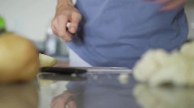 Genç bir adam mutfakta yemek pişiriyor, lezzetli bir ev yemeği hazırlamaya odaklanıyor. Sıcacık bir ortamda ev yapımı, yaratıcılık ve aşçılık keyfi.