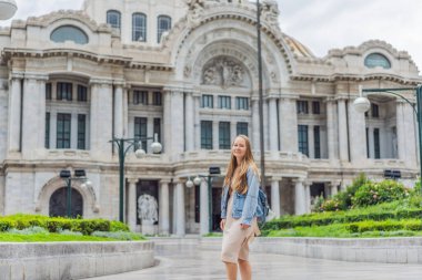 Mexico City 'de Palacio de Bellas Artes' in önünde duran kadın turist, Meksika kültürünün, mimarisinin ve simgesel seyahat simgelerinin güzelliklerini yakalıyor..