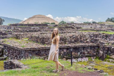 Meksika 'da Teotihuacan piramitlerinin önünde duran kadın turist gezinin, maceranın ve kültürel mirasın tadını çıkarıyor. Seyahat, turizm ve keşif konsepti.