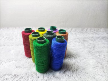 Elbise dikmek için renkli iplikler