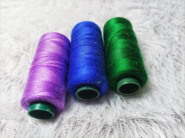 Elbise dikmek için renkli iplikler