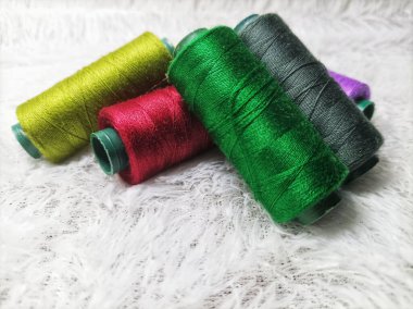 Elbise dikmek için renkli iplikler