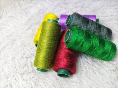Elbise dikmek için renkli iplikler