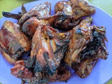 Parçalara ayrılmış tavuk ızgarayla kızartılmış.