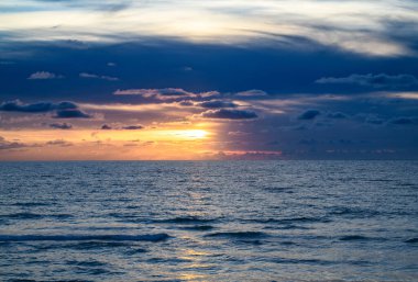 Gökyüzü ile deniz batımı. Gökyüzü arkaplanlı okyanus dalgaları. Bulutlu gökyüzü ile gün batımı deniz manzarası. Sancak için doğa gökyüzü ve deniz arkaplanı