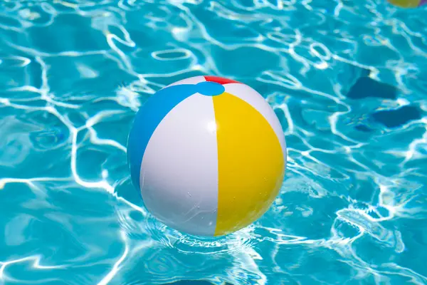 Plaj topu. Yüzme havuzunda yüzen renkli şişme top. Yaz tatili kavramı. Yaz reklamı