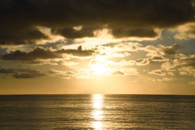 Deniz dalgaları arka planı ya da okyanus ufku. Güneşin doğuşuyla ya da batışıyla deniz manzarası. Arka plan için okyanus gün batımı gökyüzü. Arkaplan veya arkaplan için deniz dalgaları