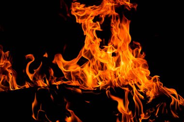 Siyah arka planda yangın alevleri. Yangın arka plan kıvılcımları. Soyut koyu alevler arka planı. Alevlerin arka planı