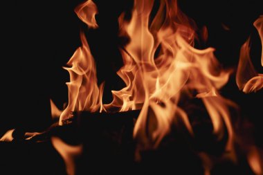 Siyah arka planda yangın. Yangın arka plan kıvılcımları. Soyut alevler arka planı. Yanan ateş. Siyah arkaplanda ateşin dokusu