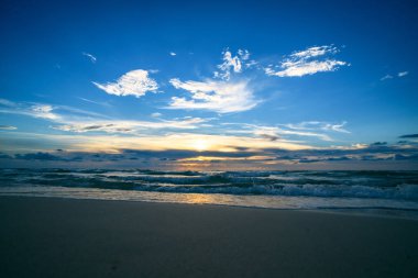 Manzaralı sahil manzarası. Okyanus dalgaları arka planı. Bulutlarla kaplı denizde gün doğumu