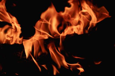 Siyah arka planda yangın. Yangın arka plan kıvılcımları. Soyut alevler arka planı. Yanan ateş. Siyah arkaplanda ateşin dokusu