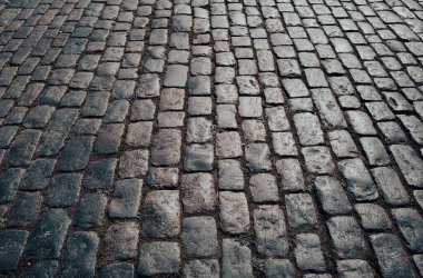 Taş yol. Kaldırım dokusu. Tasarım için taş işçiliği arka planı. Granit kaldırım taşlı zemin. Çakıl taşı kaldırımının soyut arkaplanı