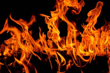 Arka plan için ateş ve alevler. Parlak alevler arka planı. Siyah arka planda ateş dokusu. Yanan kırmızı ateş. Geceleyin büyük bir yangın.