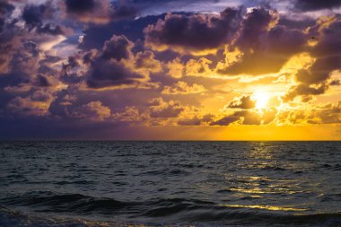 Renkli gökyüzü ve güneş ışınları. Fırtınalı dramatik gökyüzü. Okyanusun üstünde büyük bulut. Gün batımında karanlık bulutlu bir gökyüzü. Deniz zeminli bulutlu gökyüzü
