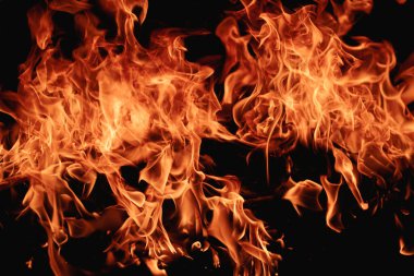 Siyah arka planda yangın. Yangın arka plan kıvılcımları. Soyut alevler arka planı. Yanan ateş. Siyah arkaplanda ateşin dokusu