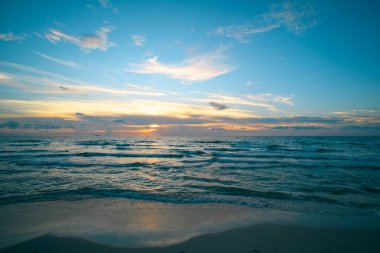 Okyanus dalgaları arka planı. Bulutlu arka planda gün doğumu. Akşamları deniz manzarası
