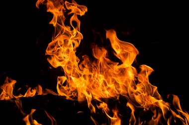 Siyah arka planda yangın alevleri. Yangın arka plan kıvılcımları. Soyut koyu alevler arka planı. Alevlerin arka planı