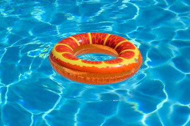 Yaz tatili kavramı. Havuzda lastik yüzük. Yüzme havuzunda yüzen renkli şişme halka. Yaz reklamı. Reklam için boşluk kopyala