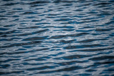 Su altyapısı. Karanlık su yüzeyi. Okyanus ya da deniz yüzeyi. Su yüzeyi arka planı. Okyanus ya da deniz suyu. Dalgalı mavi deniz yüzeyi
