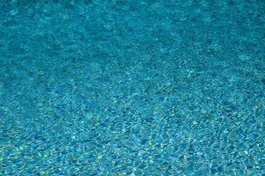Yüzme havuzu suyu. Havuz suyunun yüzeyi. Arka plan için mavi okyanus ya da deniz suyu. Havuz suyunun en üst görüntüsü. Grafik tasarımı için dalgalar