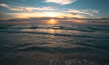 Deniz arka planı bulutlu gökyüzü. Okyanus sahilinde gün batımı ya da gün doğumu. Web tasarımı için fotoğraf