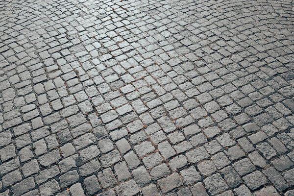 Pavement road. Background of bricks road. Stone cladding pavement. Brick surface background. Rough brick road. Cobblestone pavement background. Textured background. Sidewalk. Old cobblestone road