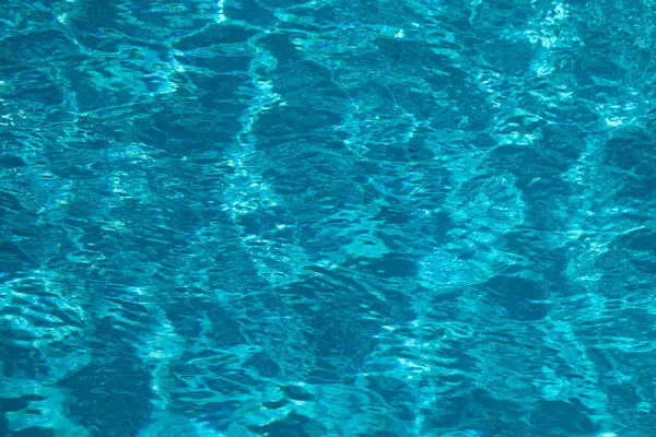 Havuz suyu. Arkaplan dokusu. Yüzme havuzunda su. Dalgalı su detayı geçmişi. Mavi su yüzeyi