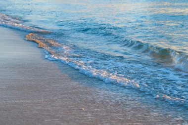 Deniz dalgaları. Denizin üzerinde gün batımı ya da denizin üzerinde gün doğumu. Deniz kumsalı. Okyanus dalgaları arka planı